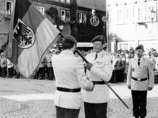 OTL Richter gibt die Truppenfahne des NschBtlSw 320 an den KArtKdr 3 Oberst Eckermann zurück